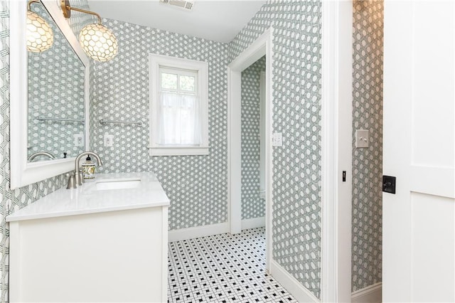 bathroom with baseboards, tile patterned floors, wallpapered walls, and vanity