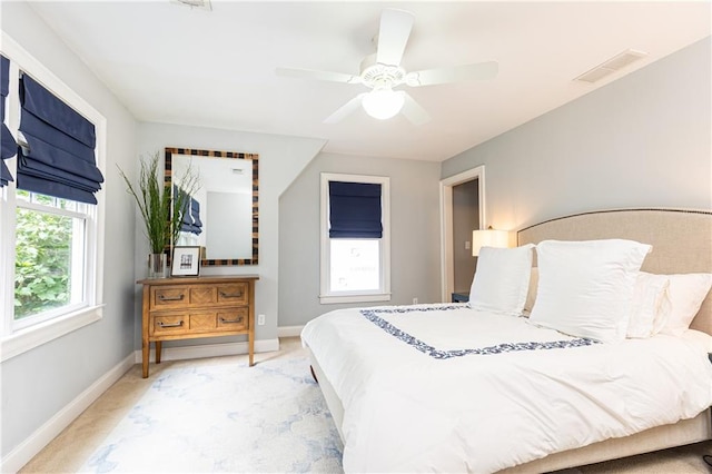 bedroom featuring light carpet, baseboards, and ceiling fan