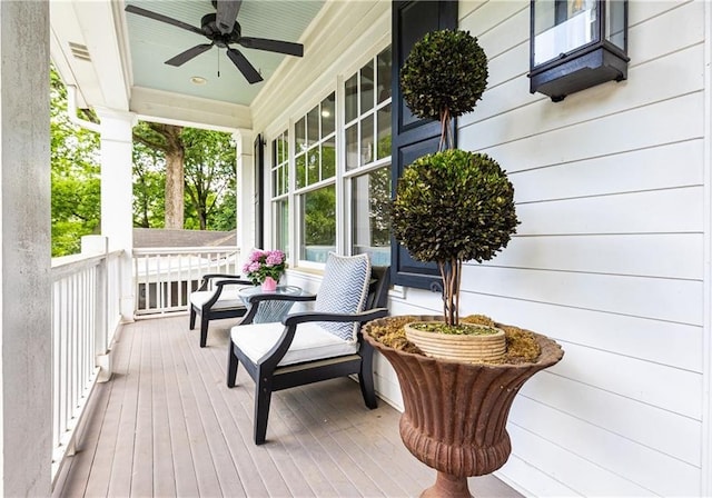 wooden deck with a porch and a ceiling fan