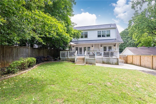 rear view of house with french doors, a wooden deck, and a patio area