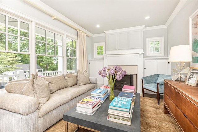 living area featuring ornamental molding, a decorative wall, and recessed lighting