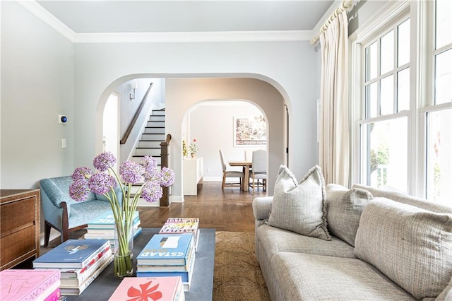 living area featuring arched walkways, healthy amount of natural light, ornamental molding, and wood finished floors