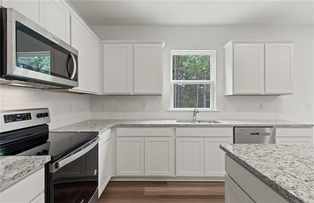 386 Rock View Ln, Covington, GA 30016 - kitchen with stainless steel appliances, a sink, white cabinetry, dark wood finished floors, and decorative backsplash