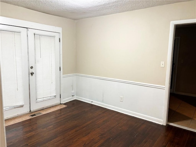 entryway with french doors, a textured ceiling, and dark hardwood / wood-style floors