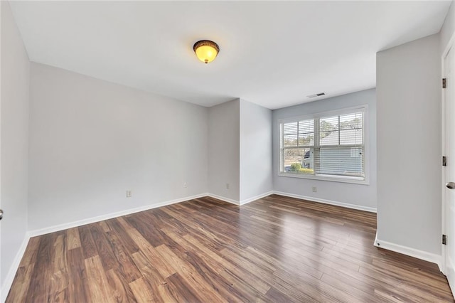 empty room with dark hardwood / wood-style flooring