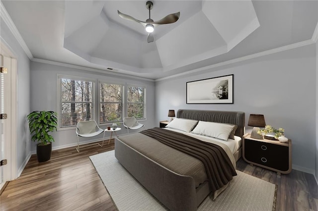 bedroom featuring crown molding, ceiling fan, dark hardwood / wood-style floors, and a raised ceiling