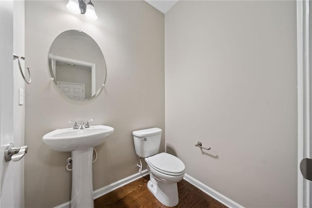 bathroom with hardwood / wood-style flooring, sink, and toilet