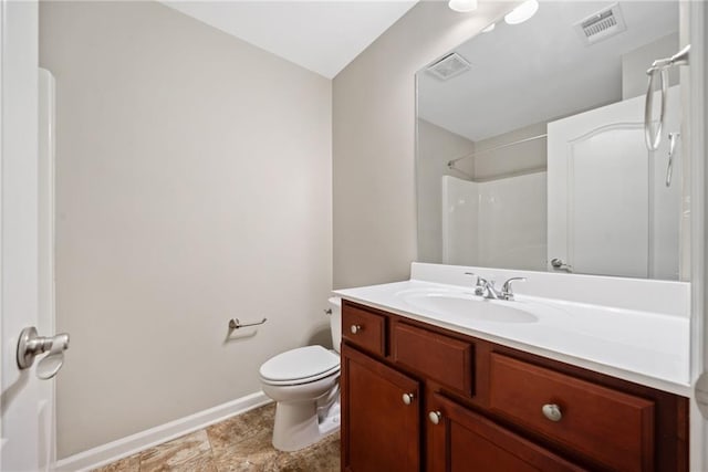 bathroom featuring vanity, a shower, and toilet