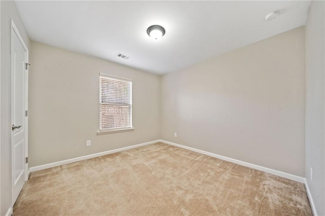 spare room featuring light colored carpet