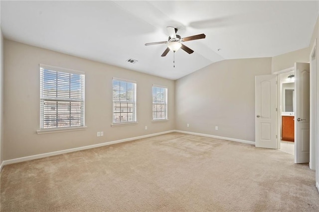 empty room with ceiling fan, vaulted ceiling, and light carpet