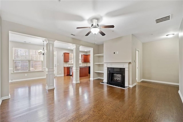 unfurnished living room featuring decorative columns, dark hardwood / wood-style floors, and ceiling fan