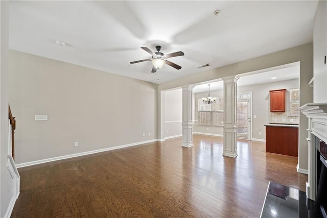 unfurnished living room with decorative columns, dark wood-type flooring, and ceiling fan with notable chandelier