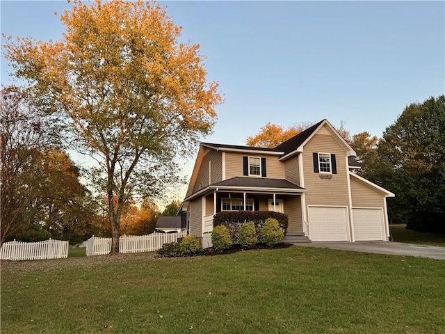 view of front property featuring a garage, a yard, and a porch