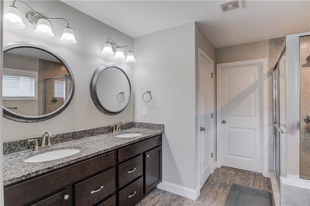 full bathroom with a shower stall, a sink, and visible vents