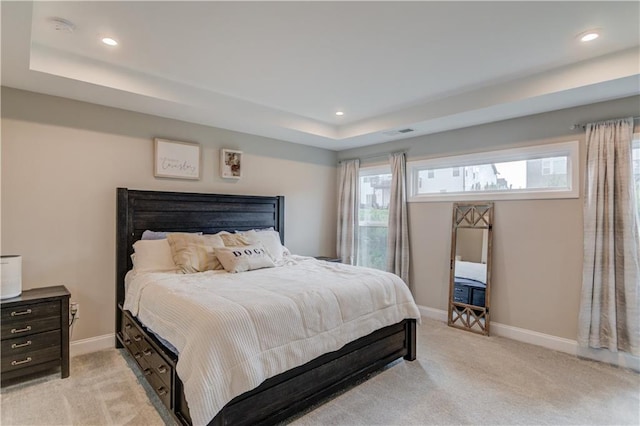 bedroom with recessed lighting, a raised ceiling, baseboards, and light colored carpet