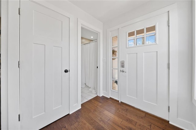 foyer entrance featuring baseboards and dark wood-style flooring