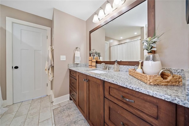 full bathroom with vanity and baseboards