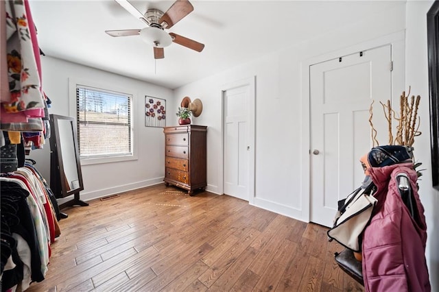 bedroom featuring wood finished floors, visible vents, baseboards, and ceiling fan