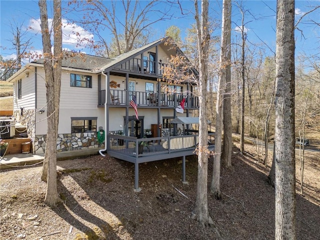 back of house featuring a wooden deck and a balcony