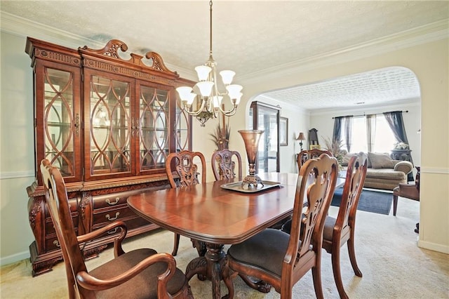 carpeted dining area with crown molding, a textured ceiling, and a notable chandelier