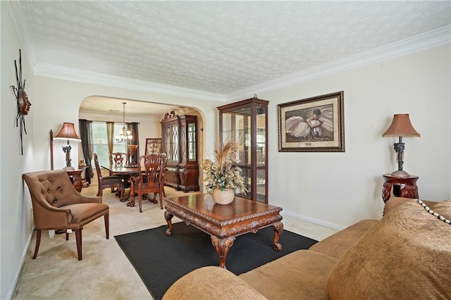 living room with light carpet, an inviting chandelier, a textured ceiling, and crown molding