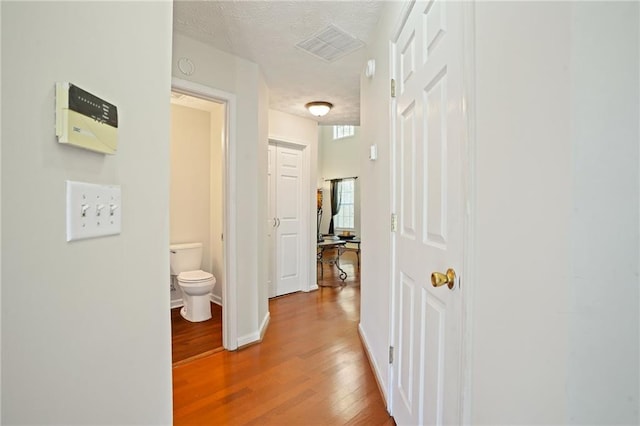 hall featuring a textured ceiling and wood-type flooring