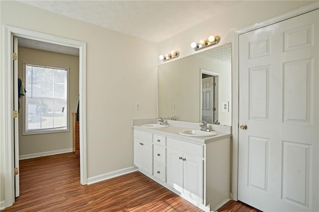 bathroom with vanity, a textured ceiling, and hardwood / wood-style flooring