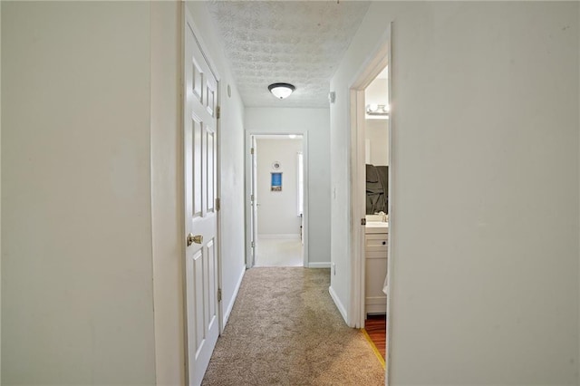 corridor featuring a textured ceiling and carpet floors