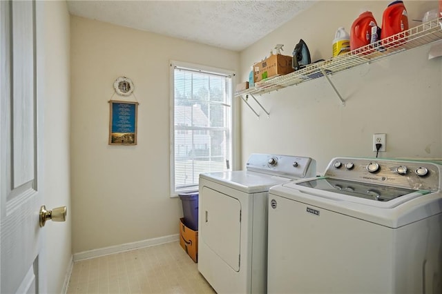 laundry area with independent washer and dryer and a textured ceiling