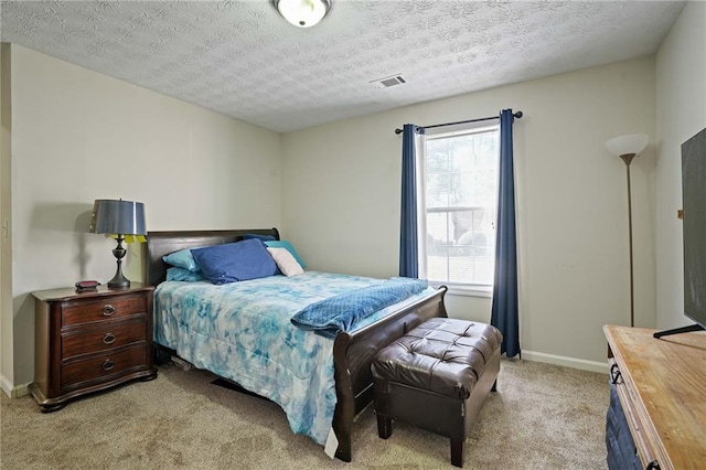 bedroom with a textured ceiling and light colored carpet