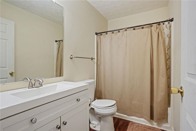 bathroom with a textured ceiling, hardwood / wood-style flooring, toilet, vanity, and a shower with curtain