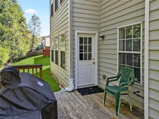 wooden terrace featuring area for grilling and a lawn