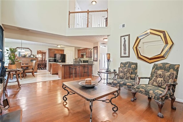 living room with a high ceiling and light hardwood / wood-style flooring