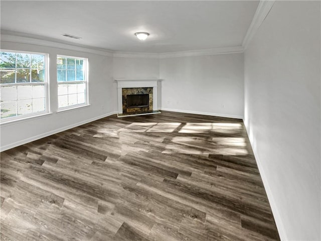 unfurnished living room with visible vents, crown molding, baseboards, a fireplace, and dark wood-style flooring