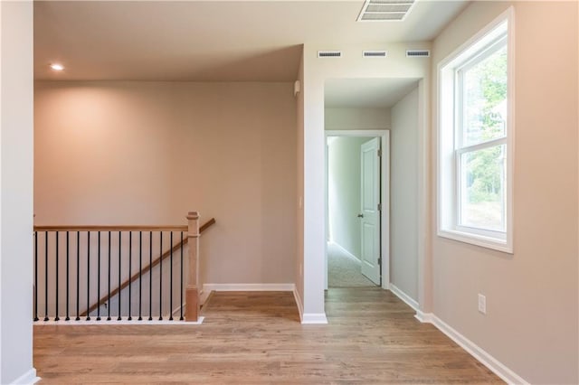 corridor with visible vents and an upstairs landing