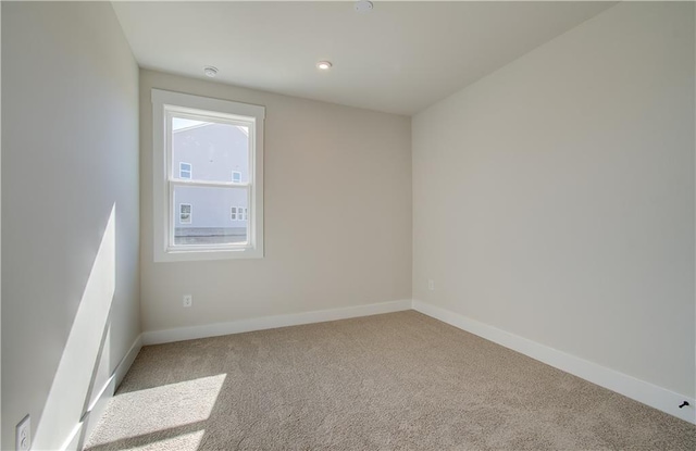 carpeted spare room featuring baseboards