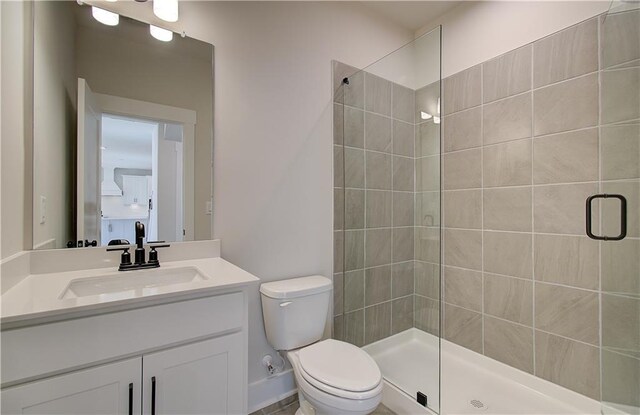 full bathroom with vanity, a shower stall, and toilet