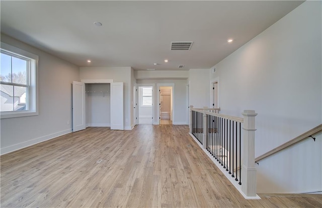 empty room with recessed lighting, baseboards, visible vents, and light wood finished floors