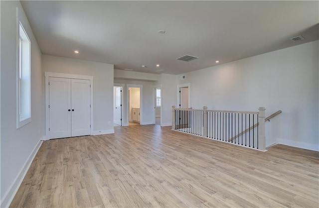 empty room with recessed lighting, visible vents, light wood-style flooring, and baseboards