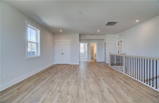 empty room featuring washer / dryer, visible vents, baseboards, light wood-style flooring, and recessed lighting