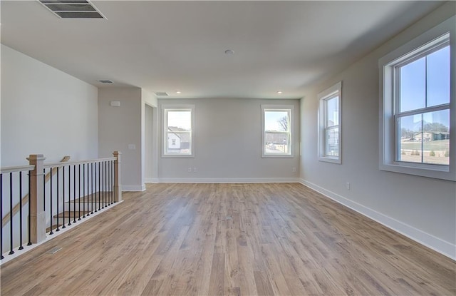 empty room with visible vents, baseboards, and wood finished floors