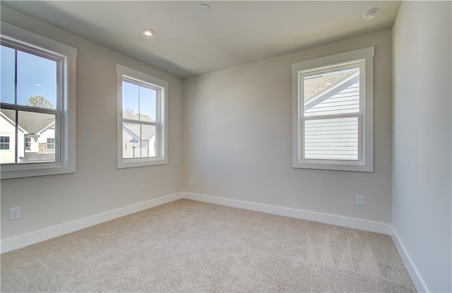 spare room featuring carpet floors and baseboards