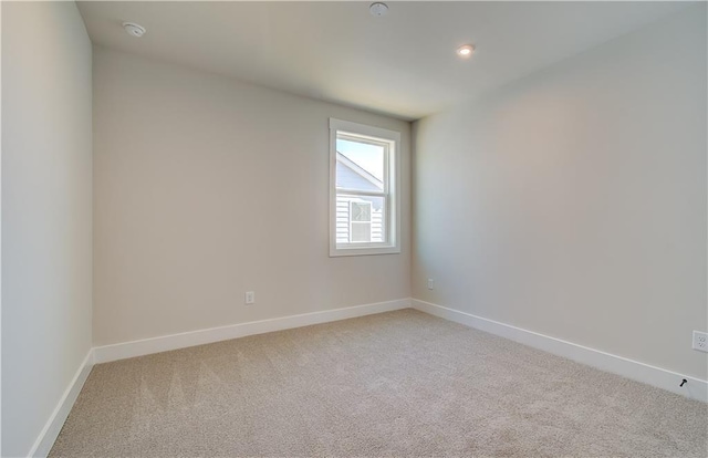 empty room with recessed lighting, light colored carpet, and baseboards