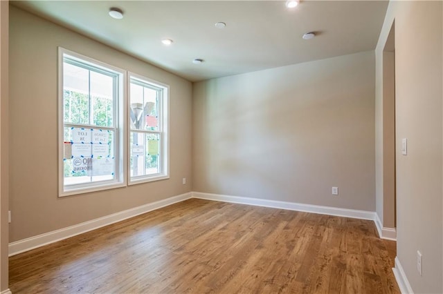 unfurnished room with baseboards and wood finished floors