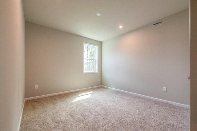 carpeted empty room featuring visible vents and baseboards