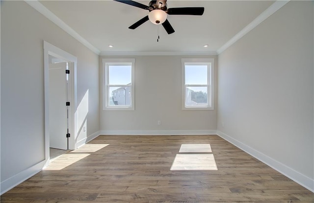 unfurnished room with a healthy amount of sunlight, crown molding, and wood finished floors