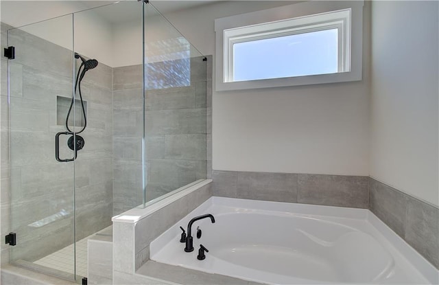 full bathroom featuring a shower stall and a bath