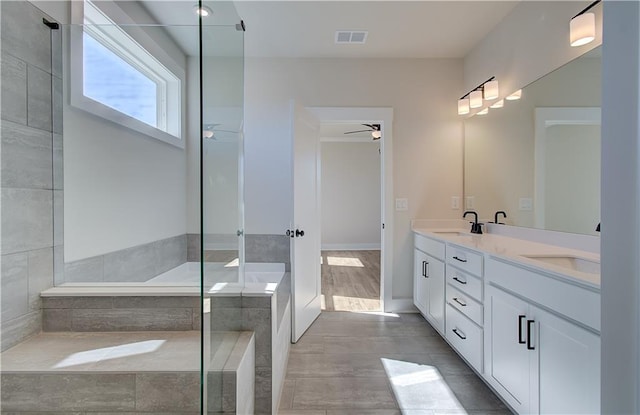 bathroom featuring ceiling fan, double vanity, a sink, and visible vents