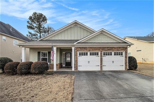 view of front facade with driveway, stone siding, and an attached garage