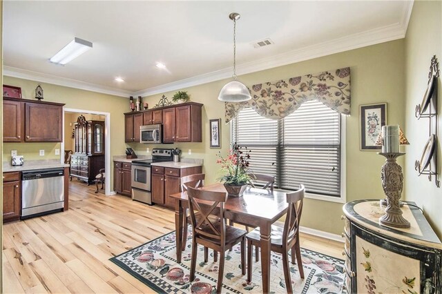 dining space with crown molding, light wood-style floors, and visible vents